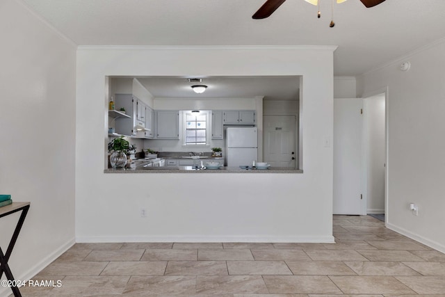 kitchen featuring a ceiling fan, open shelves, freestanding refrigerator, ornamental molding, and a sink