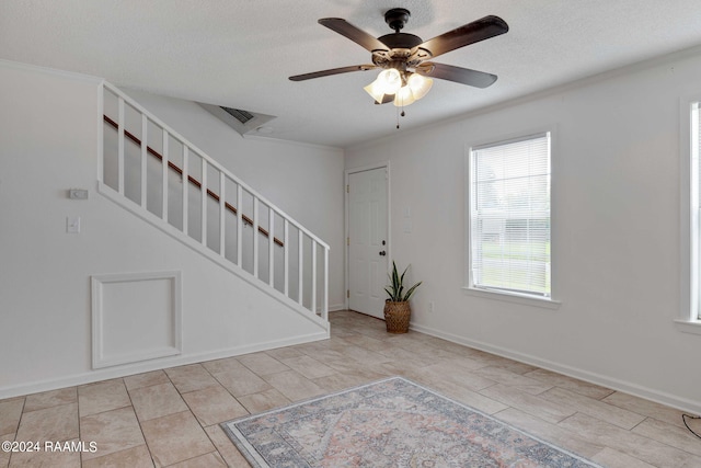 entryway featuring visible vents, baseboards, stairs, a textured ceiling, and a ceiling fan