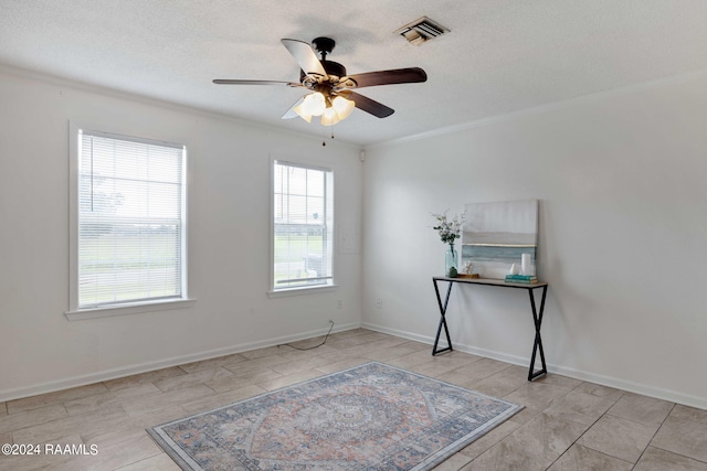 unfurnished room featuring baseboards, visible vents, ornamental molding, ceiling fan, and a textured ceiling