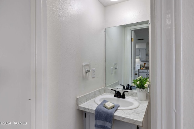 bathroom with vanity and a textured wall