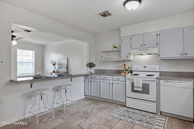 kitchen with visible vents, under cabinet range hood, a breakfast bar, white appliances, and open shelves