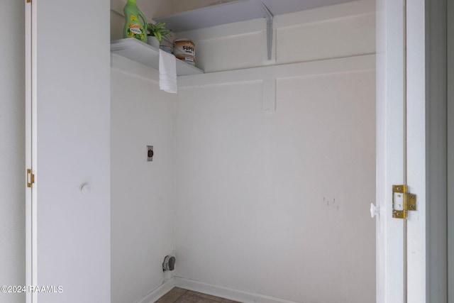 clothes washing area featuring laundry area, baseboards, and electric dryer hookup