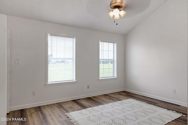 unfurnished room with vaulted ceiling, baseboards, a ceiling fan, and wood finished floors