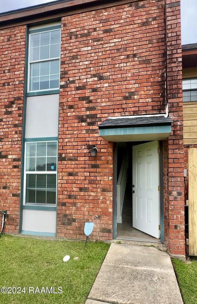 doorway to property with brick siding