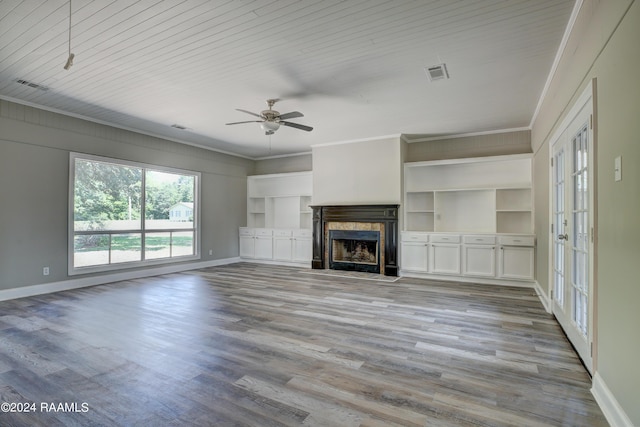 unfurnished living room with light hardwood / wood-style flooring, ornamental molding, french doors, a high end fireplace, and ceiling fan