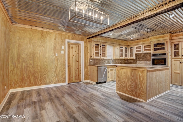 kitchen featuring light brown cabinets, light wood-type flooring, wood walls, a kitchen island, and appliances with stainless steel finishes