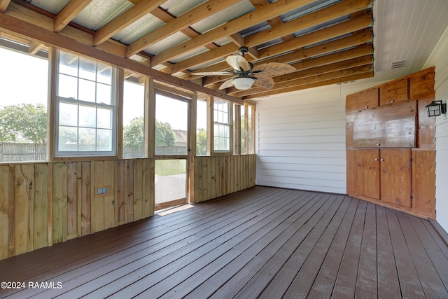 unfurnished sunroom featuring ceiling fan and a wealth of natural light