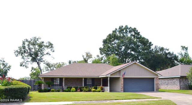 single story home featuring covered porch, a garage, and a front lawn