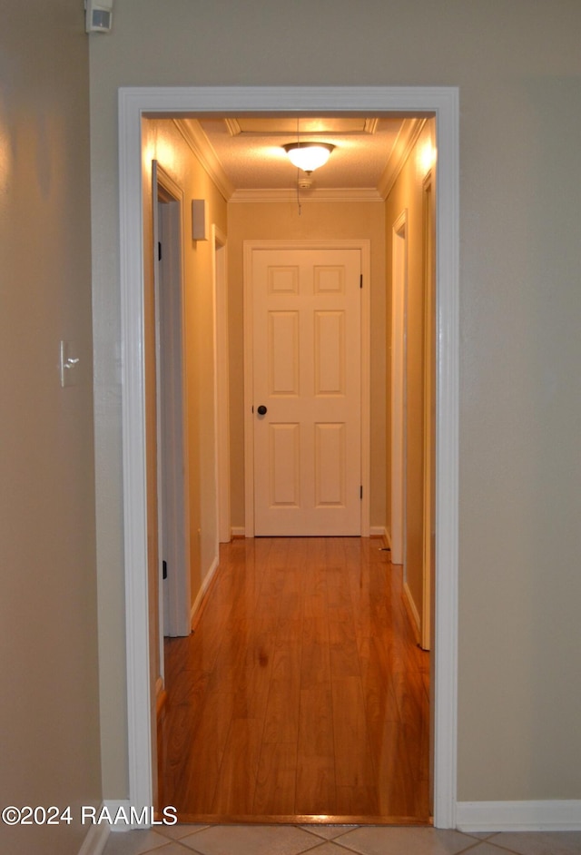 hall with ornamental molding and wood-type flooring