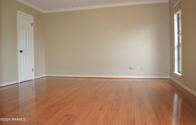 empty room featuring crown molding and light wood-type flooring