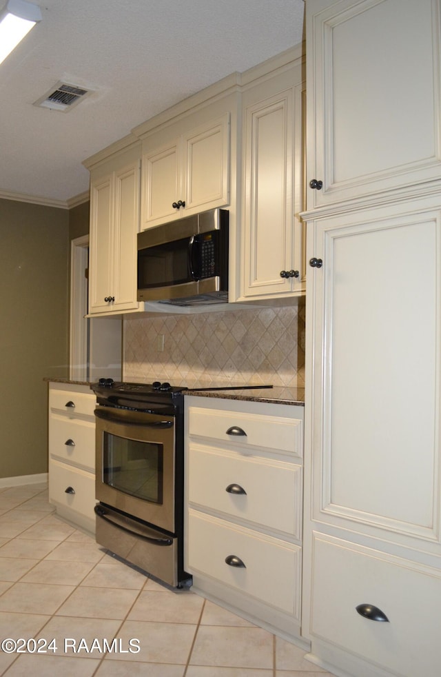 kitchen featuring stainless steel appliances, ornamental molding, light tile patterned floors, and backsplash