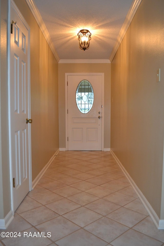 doorway with ornamental molding, a textured ceiling, and light tile patterned flooring