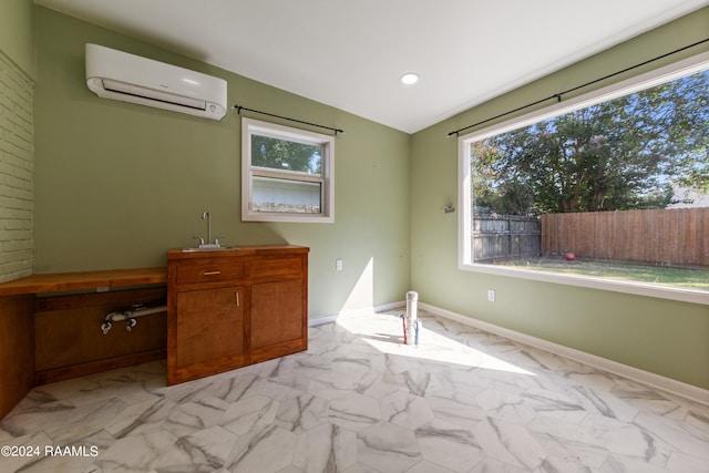 unfurnished bedroom with light tile patterned flooring, sink, and a wall mounted air conditioner