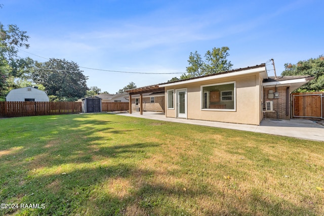 rear view of house featuring a lawn, a storage shed, and a patio