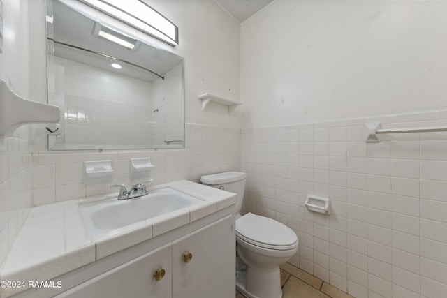 bathroom with backsplash, toilet, tile patterned flooring, vanity, and tile walls