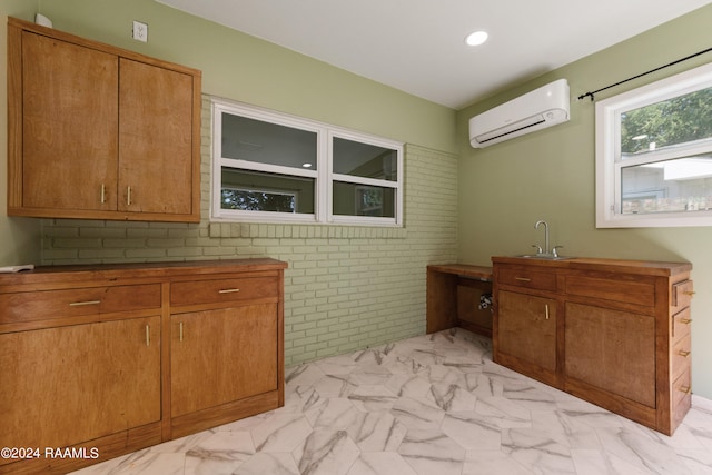 kitchen with sink, brick wall, light tile patterned floors, and an AC wall unit