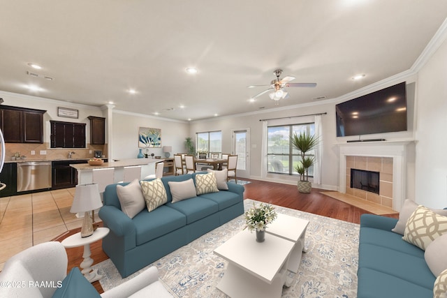 211 Vermont Dr, Carencro, LA 70520 - living room with ceiling fan, recessed lighting, a tile fireplace, crown molding, and light wood-style flooring