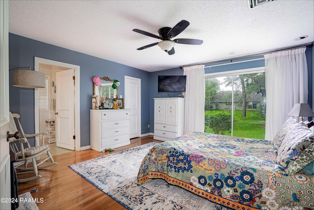 bedroom featuring hardwood / wood-style floors, ceiling fan, access to outside, and a textured ceiling