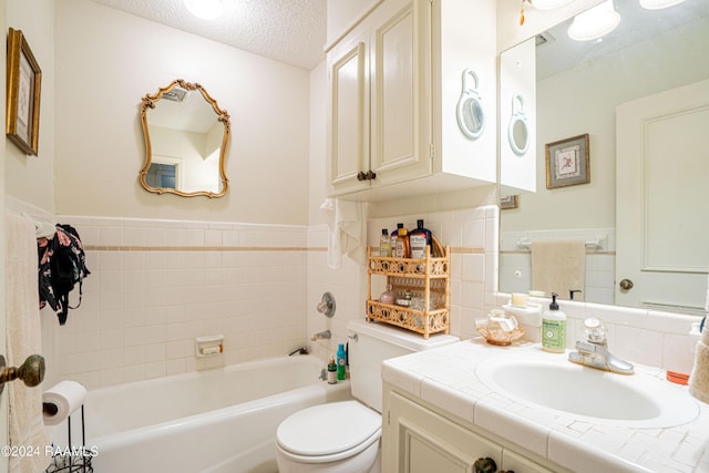 bathroom featuring vanity, tile walls, toilet, and a textured ceiling