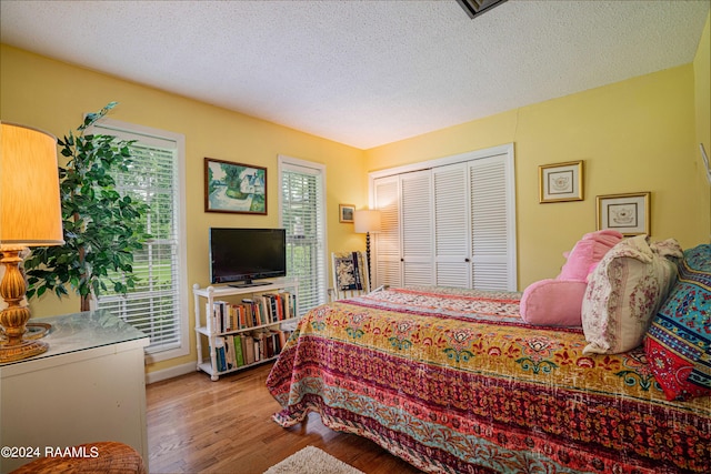 bedroom featuring a closet, a textured ceiling, and light wood-type flooring