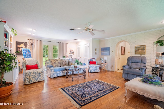 living room with hardwood / wood-style flooring, ornamental molding, and a textured ceiling