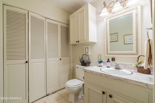 bathroom featuring vanity, toilet, tile patterned flooring, and a textured ceiling