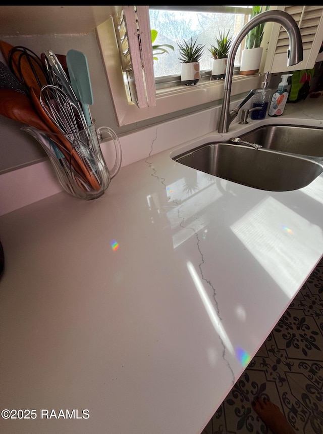 interior details featuring light stone counters and sink