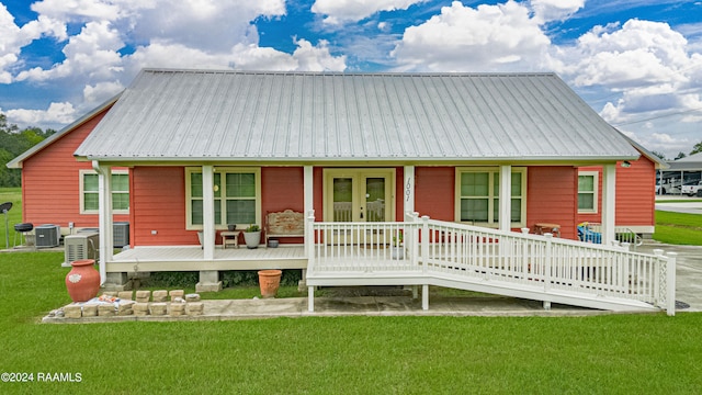 back of house with covered porch, central AC, french doors, a lawn, and metal roof