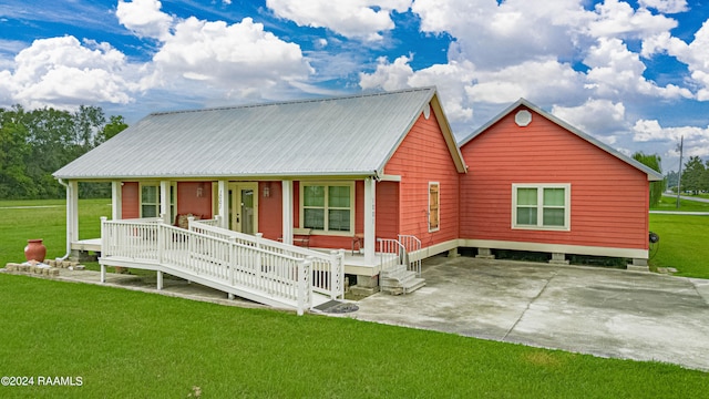 view of front of house featuring a porch, a front yard, and metal roof