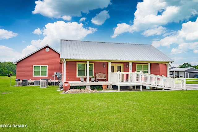 view of front facade with covered porch, a front yard, and central AC unit