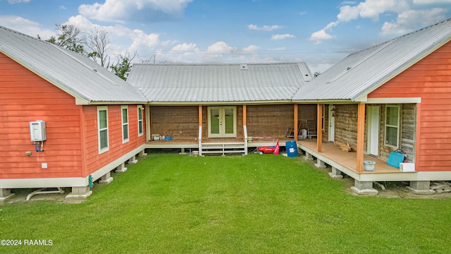 back of property with a yard, french doors, and metal roof