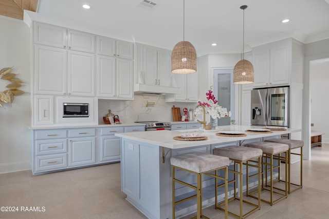 kitchen with a kitchen island with sink, decorative light fixtures, stainless steel appliances, and white cabinets