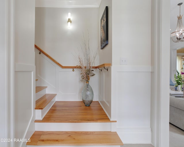 stairway featuring an inviting chandelier