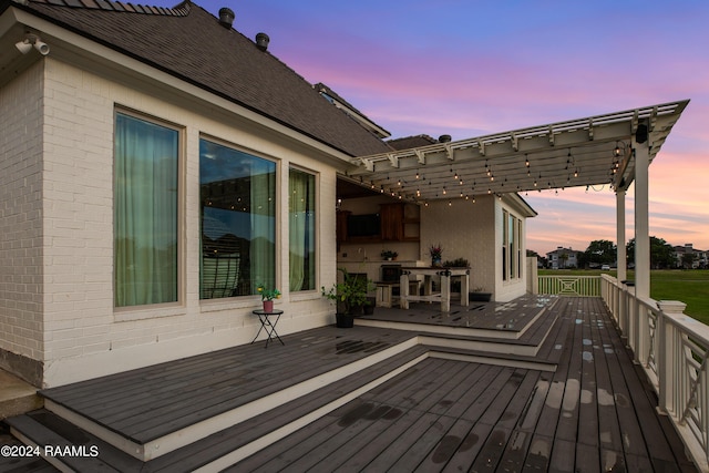 deck at dusk featuring a pergola