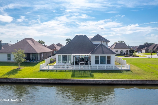 rear view of house with a water view, a yard, and a pergola