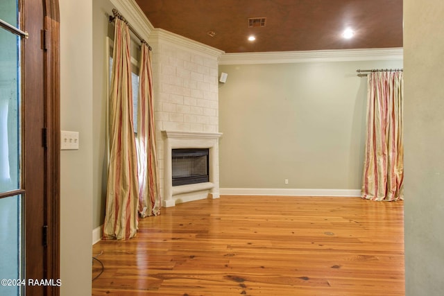 unfurnished living room with crown molding, a fireplace, and light hardwood / wood-style floors