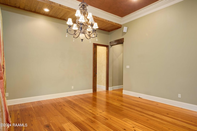 empty room with a notable chandelier, light wood-type flooring, wooden ceiling, and ornamental molding