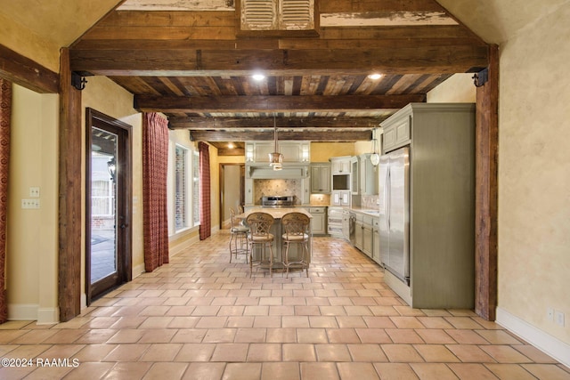 kitchen featuring decorative backsplash, a breakfast bar area, beamed ceiling, decorative light fixtures, and stainless steel refrigerator