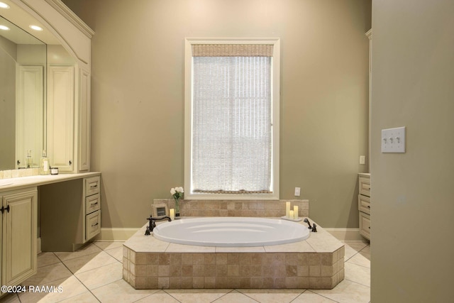 bathroom featuring vanity, a relaxing tiled tub, and tile patterned flooring