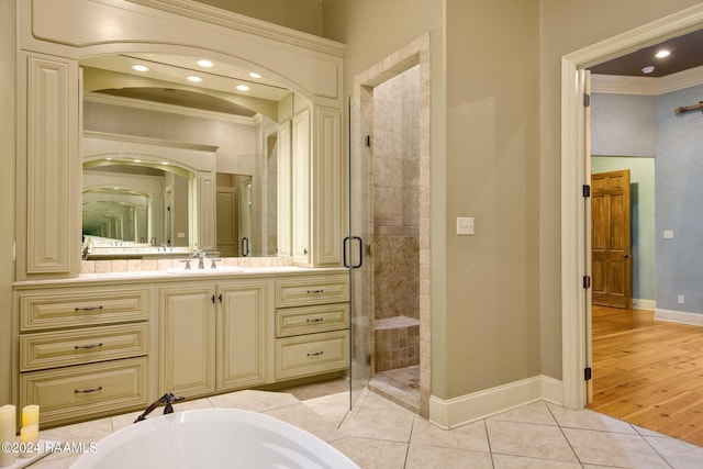 bathroom with tile patterned floors, a stall shower, ornamental molding, baseboards, and vanity