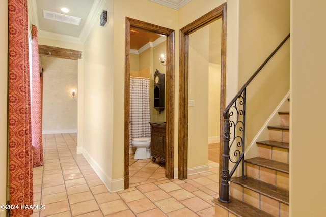 hall featuring crown molding and light tile patterned floors