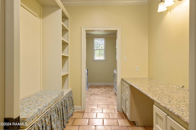 interior space featuring light tile patterned floors, baseboards, ornamental molding, and built in study area