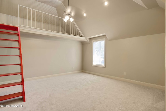 interior space with ceiling fan, carpet floors, and lofted ceiling