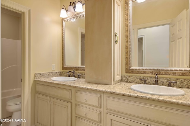 bathroom with toilet and dual bowl vanity