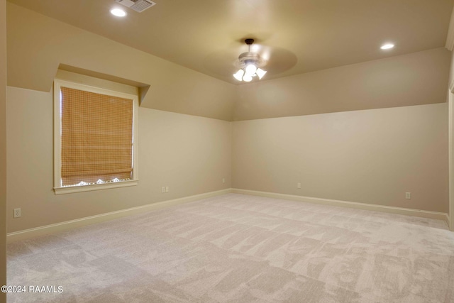 unfurnished room featuring baseboards, lofted ceiling, and light colored carpet