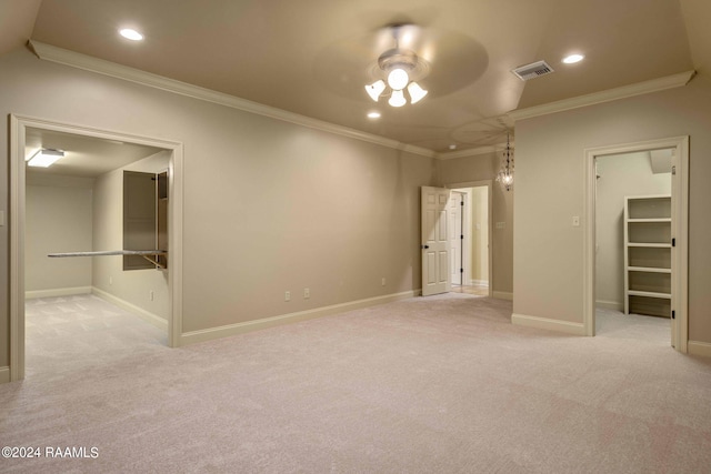 unfurnished bedroom with visible vents, ornamental molding, a spacious closet, a closet, and light carpet