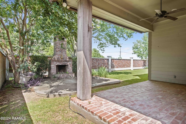 view of patio with fence, an outdoor brick fireplace, and ceiling fan