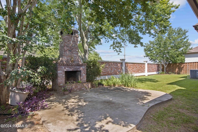 view of yard featuring central air condition unit, an outdoor brick fireplace, and a patio area