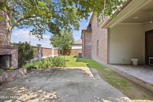 view of patio / terrace featuring an outdoor brick fireplace and fence