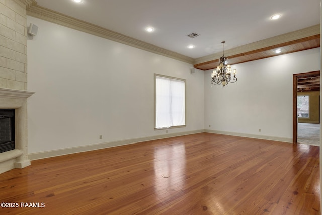 unfurnished living room featuring visible vents, a large fireplace, crown molding, and light wood finished floors